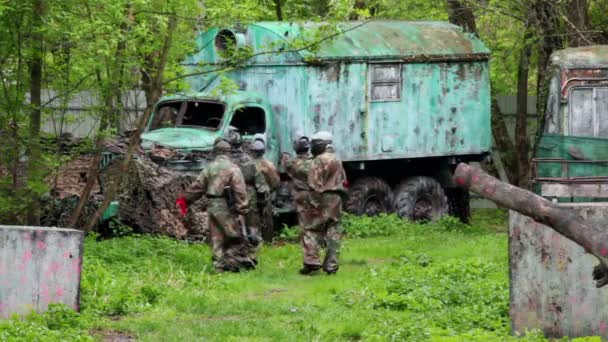 Fünf Männer Paintball-Team zu Fuß zu alten LKW — Stockvideo