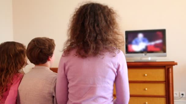 Madre con niños niño y niña pequeña sentarse ver la televisión — Vídeos de Stock
