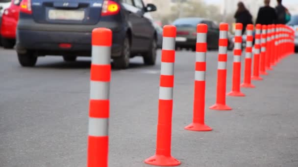 Schutzplanke aus gestreiften Säulen, Menschen und Autos auf der Straße — Stockvideo