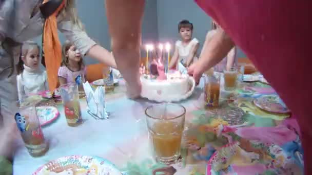 Hands of adult cut torte on birthday of child — Stock Video
