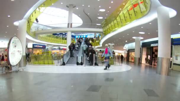 Lidé jdou na eskalátoru v obchodní centrum trojky — Stock video