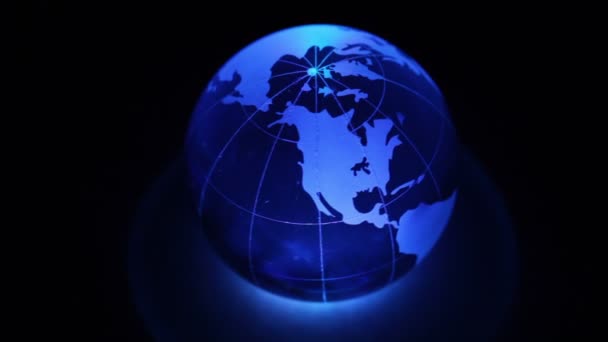 Sphère tourne avec la carte du monde sur elle et l'éclairage des couleurs 