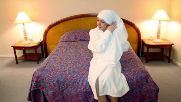 Donna in accappatoio bianco viene in camera da letto e pulire i capelli da asciugamano — Video Stock