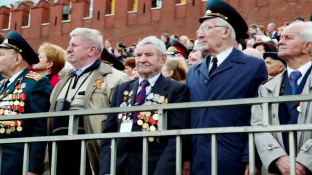 De nombreux vétérans se tiennent sur la place Rouge près du mur du Kremlin et de la tour Spasskaya — Video