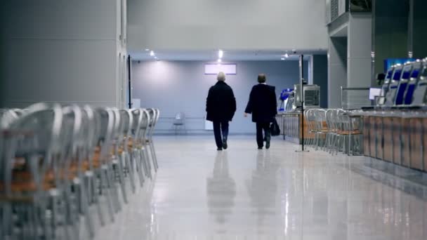 Elderly couple walk away in café — Stock video