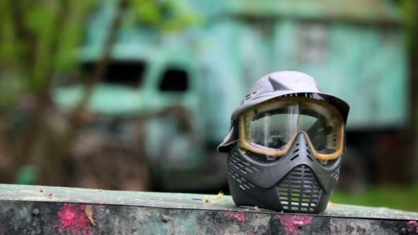 Boy comes closer to helm for paintball at background of blue truck on rainy day — Stock Video