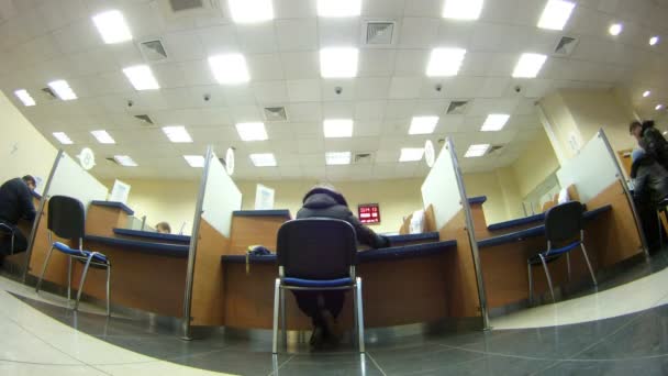 Cliente sentarse en la silla y hace transacciones en el banco — Vídeos de Stock