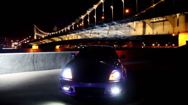 Soporte de coche con luces de estacionamiento parpadea en el fondo del puente — Vídeos de Stock
