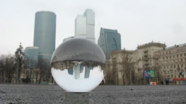 Center Moscow City is visible through transparent glass ball lying on road — Stock Video