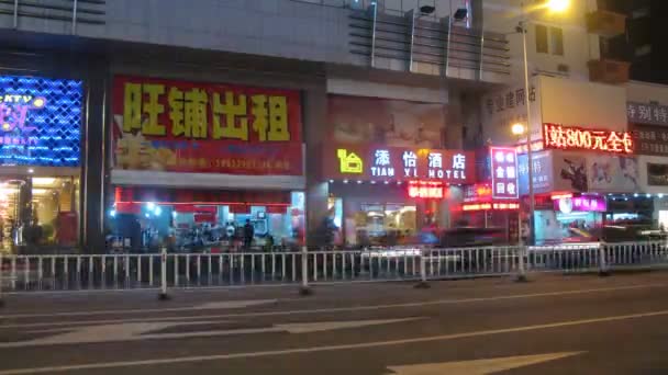 Machines go at night on highway along shops and café — 图库视频影像