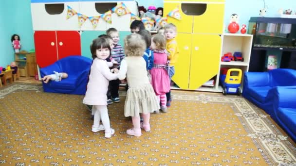 Anak-anak yang baik berpegangan tangan, berdiri di lingkaran berkumpul dan menyimpang di taman kanak-kanak Moskow 143 — Stok Video