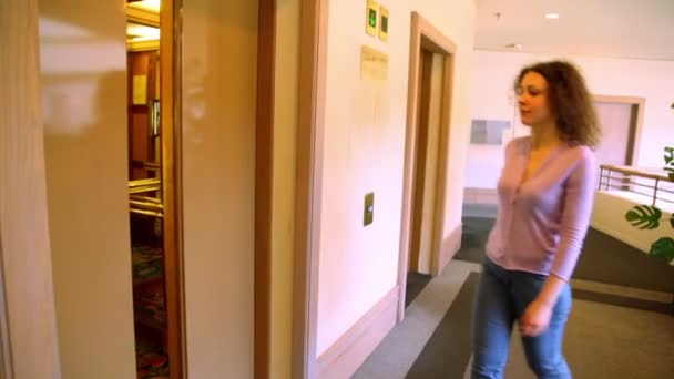 Automatische deuren opent en jonge vrouw komt in de lift — Stockvideo