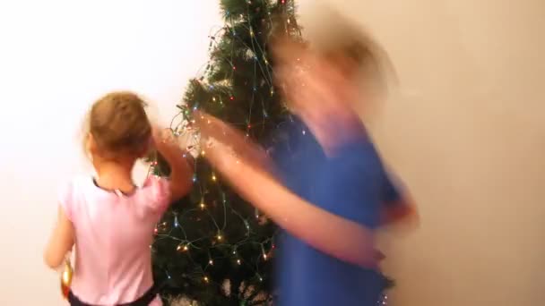 Girl and boy decorate New Year tree by New Year — Stock Video