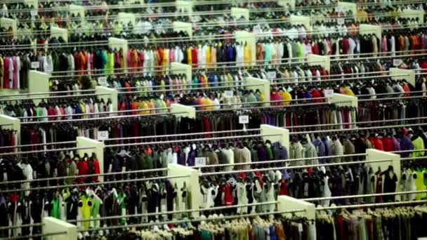 Een klant lopen onder kleding in de winkel departement — Stockvideo