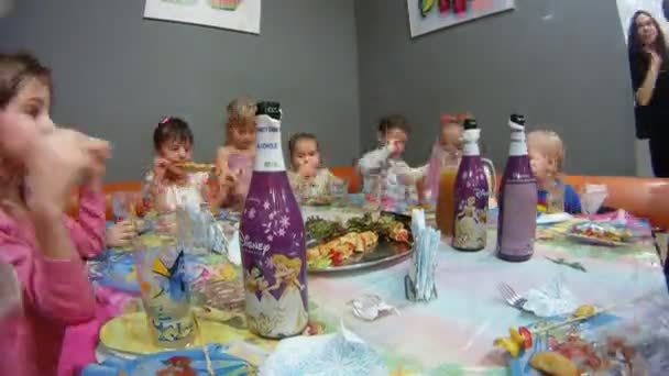 Adultos servicio niños sentados en la mesa festiva — Vídeo de stock