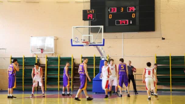 Lanza la pelota y lucha bajo la canasta en el partido de baloncesto estudiantil — Vídeo de stock