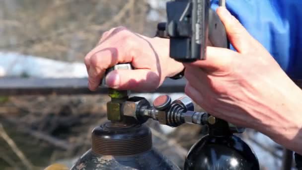 Mans ruce pracují s plyn válec a paintball gun — Stock video