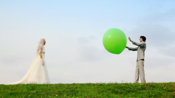 Newly married play meadow with each other inflatable sphere — Stock Video
