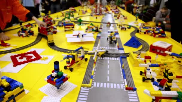 Barn leka med leksak järnvägen mellan olika objekt — Stockvideo