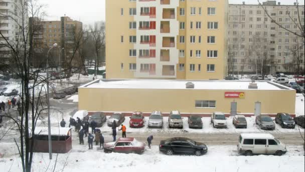 Гостевые работники чистят снег на парковке возле автомойки 24 часа в сутки — стоковое видео
