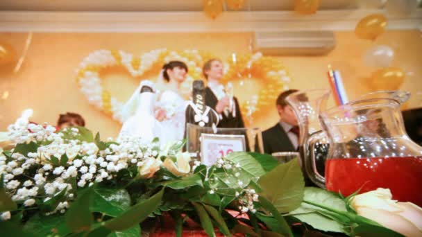 Newly-married couple stands up for festive table and holds glasses — Stock Video