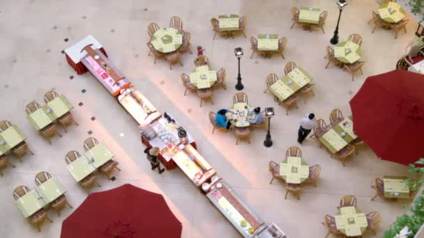 People walk and sit at tables in café — 图库视频影像