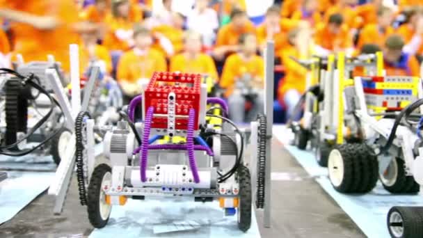 Robots de juguete de pie en la mesa en el fondo de muchos niños — Vídeo de stock