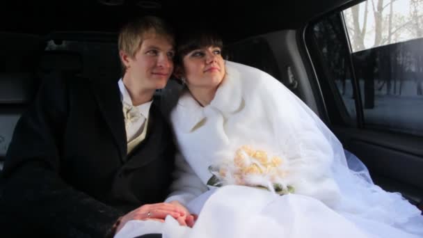 Frisch verheiratetes Paar sitzt in Limousine — Stockvideo