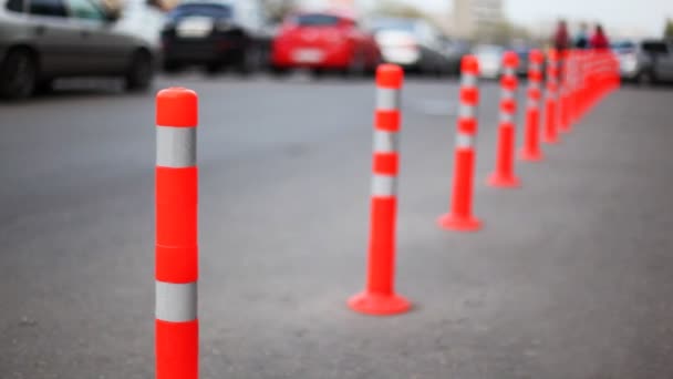Barriera protettiva fatta di colonne a strisce, persone e auto vanno su strada — Video Stock