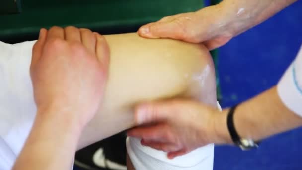 Deportivo médico hace masaje lesionado rodilla de deportista después de trauma en baloncesto — Vídeo de stock