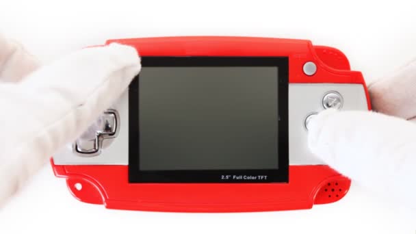 Руки в белых перчатках Нажмите на кнопки портативной игровой консоли — стоковое видео