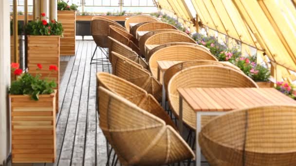 Stůl se židlemi a květiny stojí na terase restaurace v horním patře — Stock video