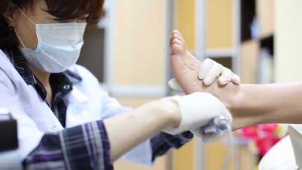 Cosmetician grinds woman heel on doing pedicure in salon — Stock Video