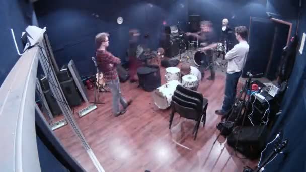 Участники музыкальной группы готовят оборудование для репетиций в студии — стоковое видео