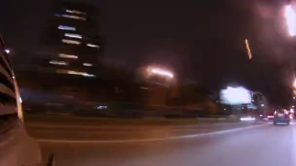 У світлі нічних ліхтарів автомобіль їде по дорозі — стокове відео