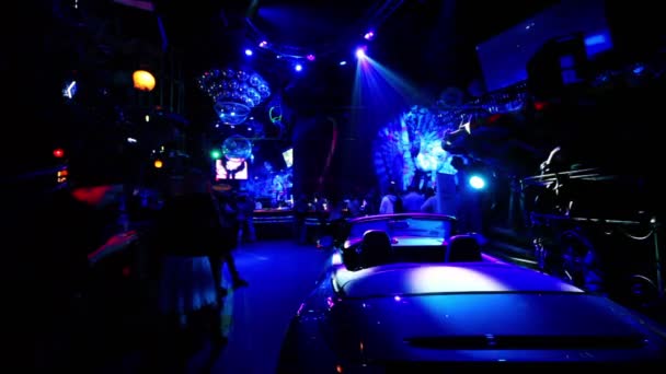 Car standin dark night club with colorful illumination — Stock Video