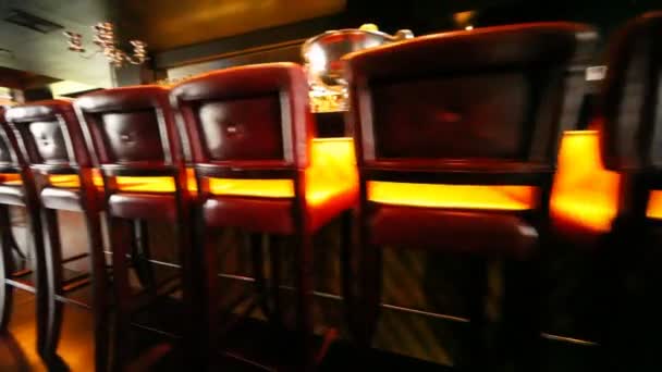 Stoelen in bar stand langs lange bar teller — Stockvideo