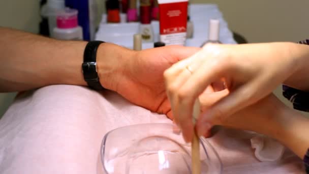 Manicure technician does to man of manicure also grinds skin of fingers — Stock Video