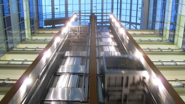 Two elevators go to business-center where light in windows of offices is shone — Stock Video