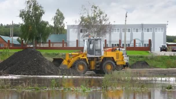 Ładowarka ładuje węgiel na Wywrotka w pobliżu wody — Wideo stockowe