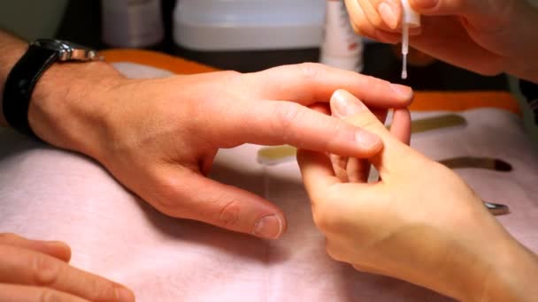 Al hombre hacen la manicura y quitan la cutícula por el medio especial — Vídeos de Stock