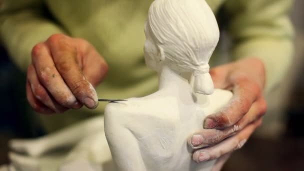 Sculptor corrects arm of female figurine by special tool — Stock Video