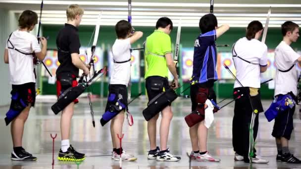 Mnoho mladých sportovce lukostřelci stojí v střelnice — Stock video