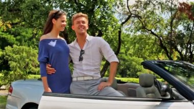 Genç çift cabriolet kucaklamak ve çocuk el yükseltir