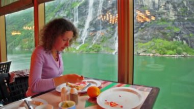 kadını masada oturur ve pencere önünde yiyor