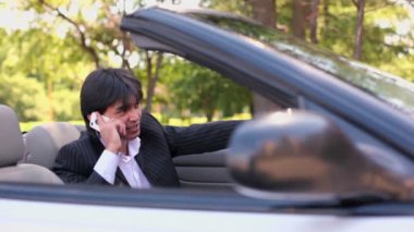 Sürücü cabriolet ve görüşmeler telefon güneşli yaz gününde oturur.
