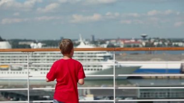 Küçük çocuk martı limanda beslemek için ekmek parçalarını atar