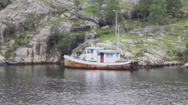 Kalemizi sahilinde üzerinde ağaçları kayalık bulutlar üzerinde ile tekne