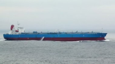 Bulutlu hava, deniz dalgaları üzerinde büyük kargo gemisi yüzer
