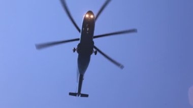 Helikopter öğleden sonra yer üstünde mavi gökyüzünde uçar